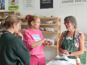 simone van olst met deelnemers workshop beeldhouwen